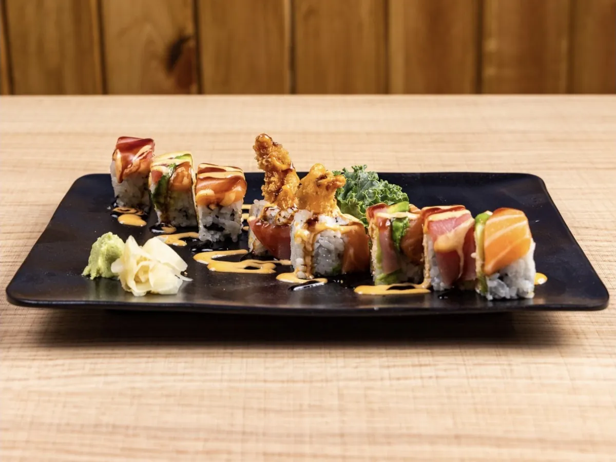 Mizu Lucky Roll topped with salmon, tuna and avocado, a shrimp tempura tail standing at the centre of the plate